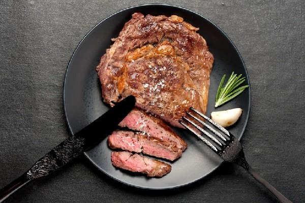 Medium Rare Grilled Steak Ribeye On Black Background. Top View